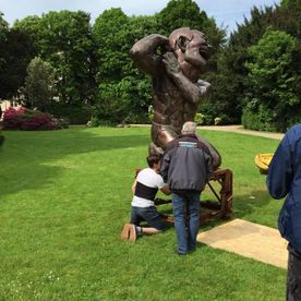hommes sur le point de déplacer une statue en bronze