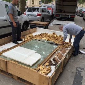 deux hommes emballant un grand miroir ancien