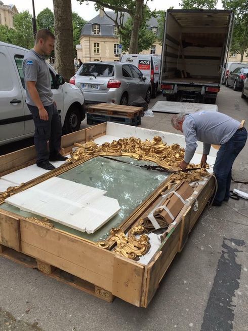 deux hommes emballant un grand miroir ancien